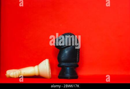 Schachfiguren Ritter einander gegenüberstellen für einen Standoff mit verschwommenen isoliert auf rotem Hintergrund. Konfrontation von Schachfiguren.Schachfiguren Ritter auf C Stockfoto