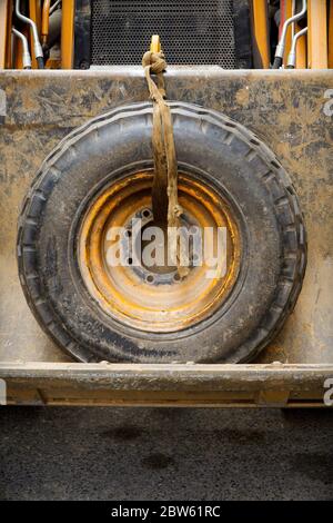 Großes Rad im vorderen Ladereimer Stockfoto