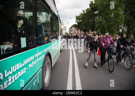 Ljubljana, Slowenien. Mai 2020. Die Fahrgäste im Bus beobachten die Fahrradfahrer während der Demonstration.Jeden Freitag protestieren Tausende Menschen in Ljubljana gegen die Regierung von Premierminister Janez Janša, weil sie die Korruption und undemokratische Herrschaft seiner Regierung beschuldigt haben. Quelle: SOPA Images Limited/Alamy Live News Stockfoto