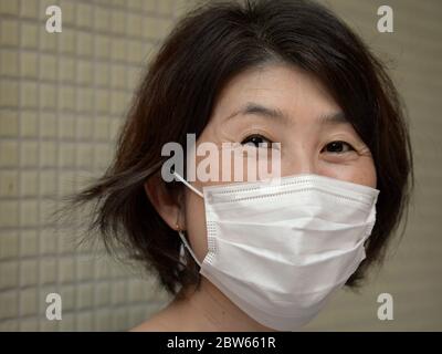 Japanische Frau trägt eine Einweg-OP-Gesichtsmaske. Stockfoto