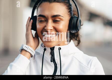 Glückliche Frau, die während des Trainings mit geschlossenen Augen Musik genießt Stockfoto