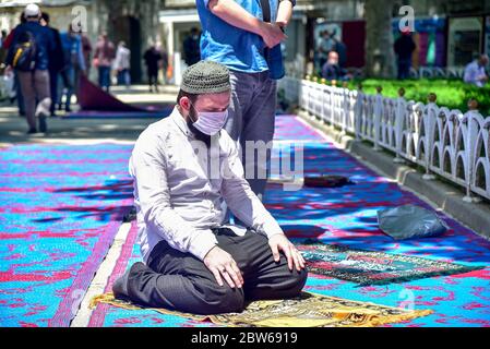 Beten mit medizinischen Masken vor der Blauen Moschee. Am ersten Freitag beten, namaz nach der Sperre in Istanbul. Muslime beten gemeinsam für Heilung Stockfoto