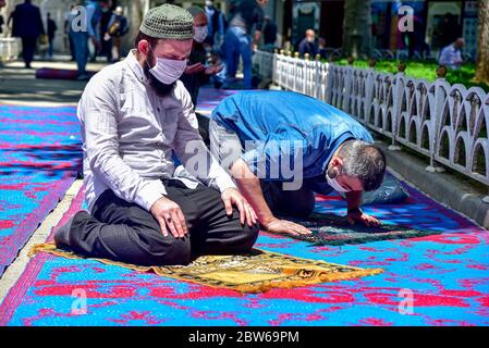 Beten mit medizinischen Masken vor der Blauen Moschee. Am ersten Freitag beten, namaz nach der Sperre in Istanbul. Muslime beten gemeinsam für Heilung Stockfoto