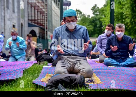 Beten mit medizinischen Masken vor der Blauen Moschee. Am ersten Freitag beten, namaz nach der Sperre in Istanbul. Muslime beten gemeinsam für Heilung Stockfoto