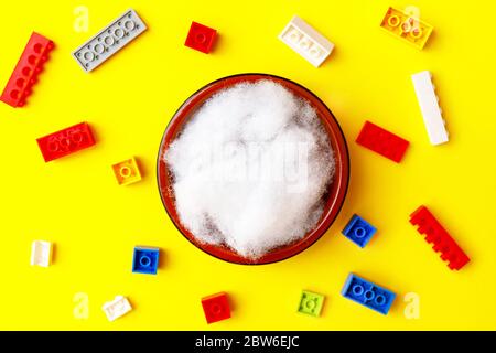 Neugeborenes digitaler Hintergrund mit bunten Ziegeln auf gelber Kulisse Stockfoto