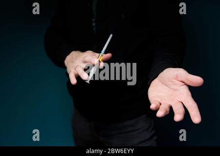 Man zeigt eine Spritze mit einem Medikament und hält eine leere Handfläche, warten auf Zahlung, selektive Fokussierung Stockfoto