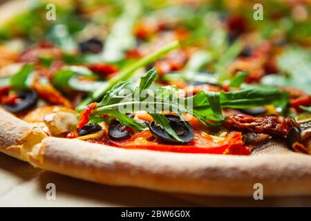 Köstliche italienische Pasta mit Rucola Blätter, schwarze Oliven und getrocknete Tomaten auf knusprigem Brot serviert im Restaurant zum Mittagessen Stockfoto