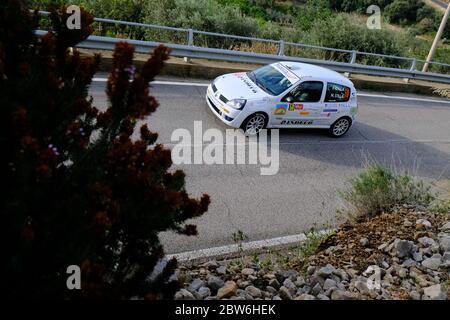 Ansicht eines Renault Clio Rennens in Rally Ronde Città di Sperlonga 2019, eingerahmt von den mediterranen Pflanzen am Straßenrand. Stockfoto