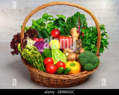 Vintage-Korb mit einer Anordnung von gemischten bunten Gemüse auf hellem Hintergrund gefüllt, sieht frisch, gesund und appetitlich, ein ganzes Essen Nutrit Stockfoto