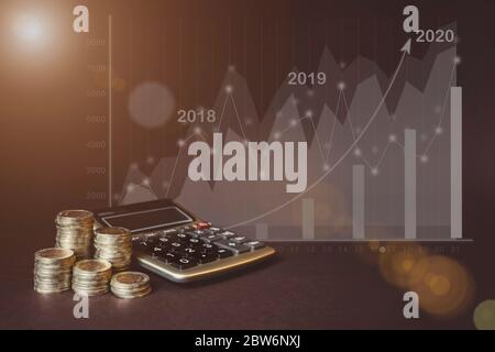 Geldmünze auf jeder Zeile steigt, Rechner, virtuelle Hologramm der Statistik, Grafik und Diagramm mit Pfeil nach oben auf dunklem Hintergrund. Die Wirtschaft des Trend Bac Stockfoto