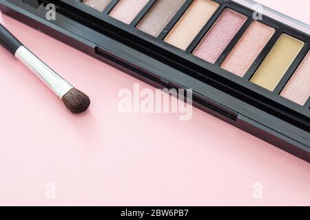 Augenschatten pallete setzen pastellbraune Farben und bürsten vor rosafarbenem Hintergrund, Nahaufnahme. Professionelle Werkzeuge für Make-up, Beauty-Salon, Kosmetik c Stockfoto