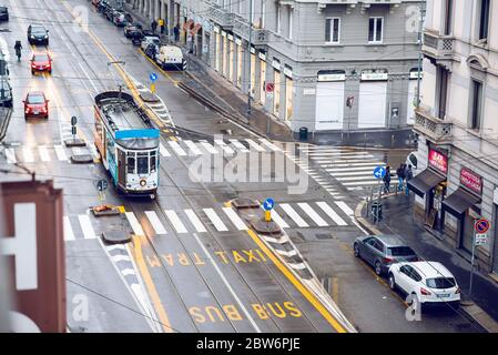 Mailand. Italien - 19. Mai 2019: Straßenpanorama in Mailand mit Straßenbahn nach Regen. Luftaufnahme. Fußgänger und Autos an einem bewölkten Tag. Bus, Taxi und Tram Lane Stockfoto