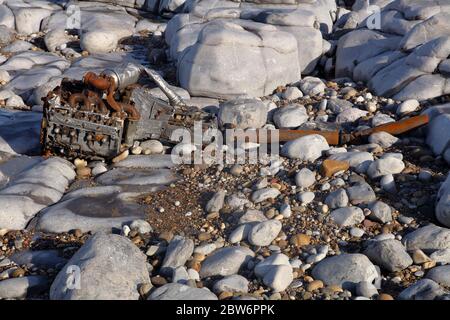 An Land gespült haben sich dieser Dieselmotor und das Getriebe seit zwei Jahren in einer kleinen Bucht an dieser Küste bewegt und fallen langsam auseinander Stockfoto