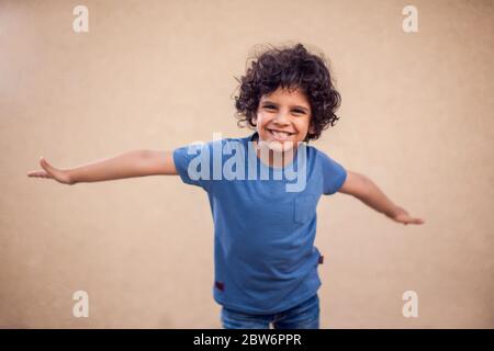 Ein Porträt von glücklichen Jungen mit lockigen Haaren. Kinder und Emotionen koncept Stockfoto