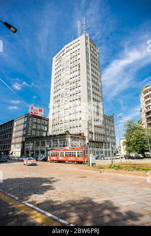 Mailand. Italien - 21. Mai 2019: Hochhaus an der Piazza della Repubblica in Mailand. Rote Straßenbahn neben dem Gebäude. Stockfoto