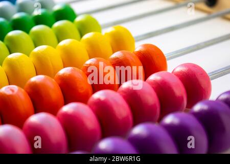 Mehrfarbiger Designer-Hintergrund. Berechnung bunten hölzernen Regenbogen Abacus für die Zahlenberechnung. Holzabakus auf weißem Hintergrund in der Nähe. Math Stockfoto