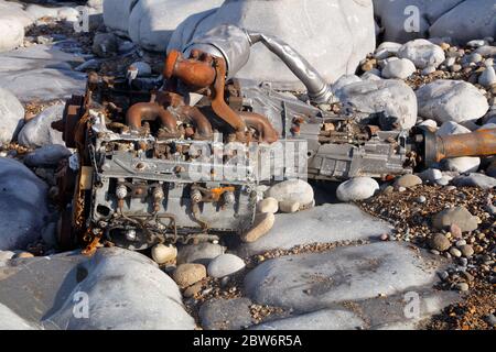 An Land gespült haben sich dieser Dieselmotor und das Getriebe seit zwei Jahren in einer kleinen Bucht an dieser Küste bewegt und fallen langsam auseinander Stockfoto