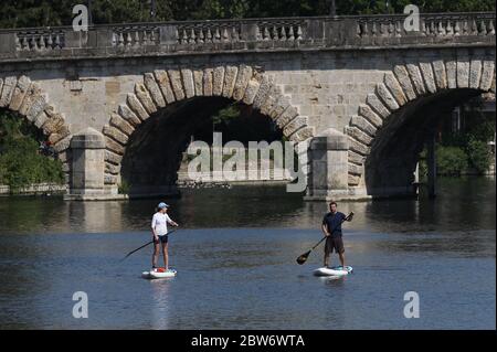 Paddelboarder passieren die Maidenhead Bridge an der Themse bei Maidenhead und genießen das gute Wetter, da die Öffentlichkeit daran erinnert wird, nach der Lockdown-Restriktionen soziale Distanz zu üben. Stockfoto