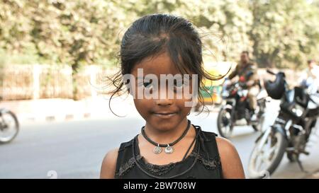 Agra, Indien - 12. Dezember 2018: Porträt eines niedlichen jungen indischen Mädchens auf den Straßen von Agra. Stockfoto