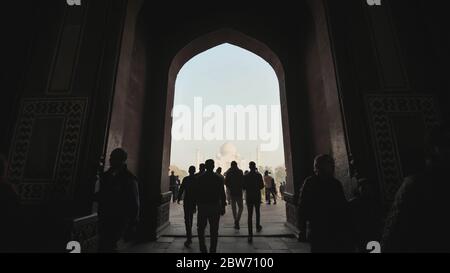 Agra, Indien - 12. Dezember 2018: Silhouette eines Bogens mit Menschen vor dem Hintergrund des Taj Mahal. Stockfoto