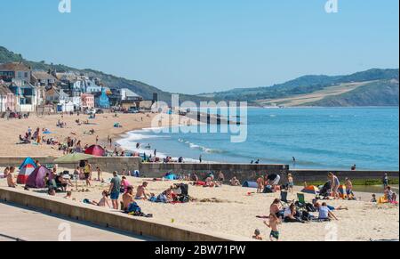 Lyme Regis, Dorset, Großbritannien. Mai 2020. Wetter in Großbritannien. Strandgänger strömen in die Küstenstadt Lyme Regis, um an einem anderen herrlichen heißen und sonnigen Tag ein gesellschaftlich distanziertes Sonnenbad zu genießen. Familien und Freunde werden noch mehr heißen Sonnenschein und brutzelnde Hitze genießen, während die Mai-Hitzewelle mit steigenden Temperaturen am heißesten Wochenende dieses Jahres anhält. Kredit: Celia McMahon/Alamy Live News Stockfoto