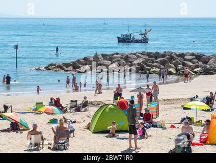 Lyme Regis, Dorset, Großbritannien. Mai 2020. Wetter in Großbritannien. Strandgänger strömen in die Küstenstadt Lyme Regis, um an einem anderen herrlichen heißen und sonnigen Tag ein gesellschaftlich distanziertes Sonnenbad zu genießen. Familien und Freunde werden noch mehr heißen Sonnenschein und brutzelnde Hitze genießen, während die Mai-Hitzewelle mit steigenden Temperaturen am heißesten Wochenende dieses Jahres anhält. Kredit: Celia McMahon/Alamy Live News Stockfoto