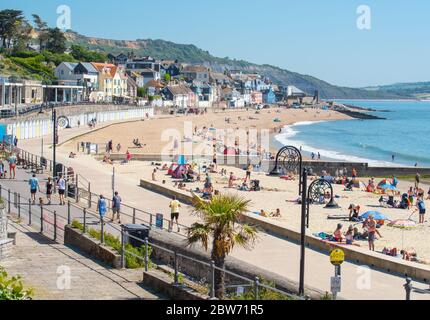 Lyme Regis, Dorset, Großbritannien. Mai 2020. Wetter in Großbritannien. Strandgänger strömen in die Küstenstadt Lyme Regis, um an einem anderen herrlichen heißen und sonnigen Tag ein gesellschaftlich distanziertes Sonnenbad zu genießen. Familien und Freunde werden noch mehr heißen Sonnenschein und brutzelnde Hitze genießen, während die Mai-Hitzewelle mit steigenden Temperaturen am heißesten Wochenende dieses Jahres anhält. Kredit: Celia McMahon/Alamy Live News Stockfoto