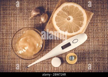 Behandlung von Erkältungen und Grippe. Verschiedene Medikamente, Thermometer, kalte Pillen, Kehlspray, Nasentropfen, Zitrone auf braunem Hintergrund. Behandlung von Einfluss Stockfoto