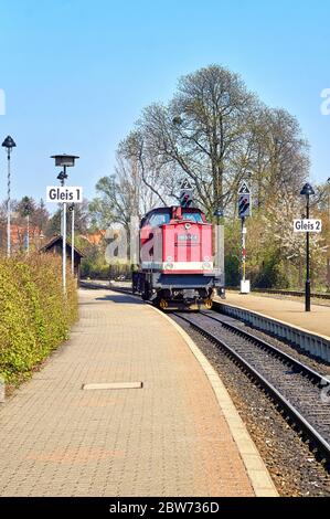 Alte rote Diesellokomotive auf einem zweigleisigen Bahnhof. Stockfoto