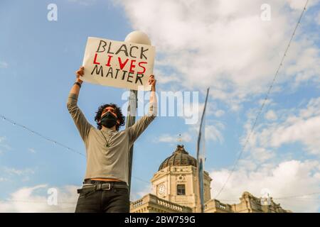 Ein Protestler hält ein Plakat mit Worten von "Black Lives Matter" während der George Floyd Morde Proteste. Demonstranten wütend über die Tötung von George Floyd durch die Polizei in Minneapolis, Minnesota märz zum Grafschaftsgefängnis in Solidarität mit anderen Demonstranten am Freitag 29 in Bloomington, Indiana. Die Proteste begannen mit einer Kundgebung, aber später gingen die Demonstranten auf die Straße und begannen, den Verkehr zu blockieren. Stockfoto