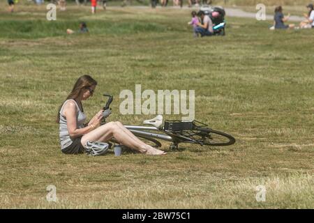 WIMBLEDON LONDON, GROSSBRITANNIEN. 30 Mai 2020. Die Menschen nutzen das warme Wetter während überdurchschnittlicher Temperaturen bis 28 Grad Celsius im Freien auf Wimbledon Common, da die Sperrbeschränkungen gelockert werden. Die Regierung hat begonnen, die Sperrbeschränkungen zu lockern und angekündigt, dass Gruppen von bis zu sechs Personen ab Montag, dem 1. Juni, in England im Freien Tagen können, vorausgesetzt, dass strenge soziale Distanzierungsrichtlinien befolgt werden. Kredit: amer Ghazzal/Alamy Live News Stockfoto