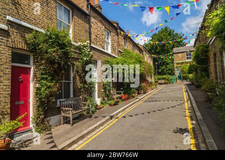 LONDON, Großbritannien - 24. MAI 2020: Süße Straßen in Greenwich London, die das Äußere von Gebäuden, viele Pflanzen und Bunting zeigen. Stockfoto