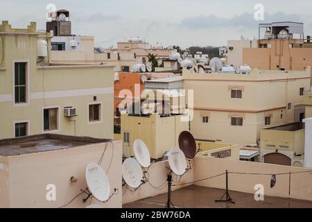 Bahrain City / Bahrain - 15. Januar 2020: Dächer von braunen Häusern mit Satellitenschüsseln in der Stadt gefüllt Stockfoto