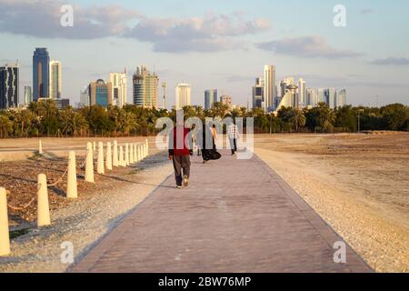 Bahrain Stadt / Bahrain - 15. Januar 2020: Muslimische Frauen tragen Balck Abaya Niqab zu Fuß in der Nähe der touristischen Qal'at al-Bahrain während Sonnenuntergang Zeit Stockfoto