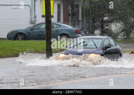 Saint John, NB, Kanada - 7. September 2019: Ein Auto fährt auf einer überfluteten Straße durch Wasser. Die Flut wurde durch Wind und Regen vom Hurrikan Dorian verursacht. Stockfoto