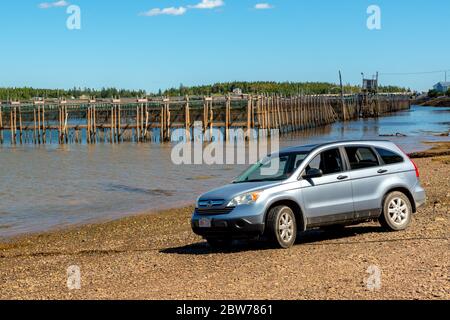 Chance Harbor, New Brunswick, Kanada - 8. September 2018: Ein Honda SUV parkt an einem Strand am Meer. Fischfarm im Hintergrund. Stockfoto