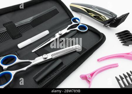 Haarschere Set Friseurwerkzeuge mit Akku-Elektro-Haarschneider sind auf weißem Hintergrund isoliert. Stockfoto