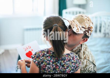 Alles gute zum Vatertag! Militärvater küsst ihn Tochter. Familienurlaub und Zweisamkeit. Stockfoto