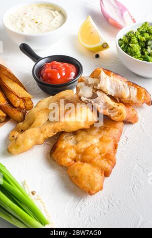 Fishand Chips zerschlagen knusprig Kabeljau Filet Detail mit Dip und Zitrone in einem Papier-Kegel auf weißem Hintergrund mit allen Komponenten klassische Rezept Take Away foo Stockfoto