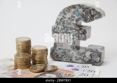 Britisches Pfund Papiergewicht aus gehackten £5 Noten neben £1 Münzen und Noten UK Stockfoto