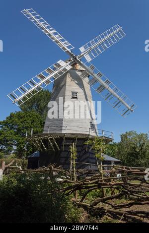 Alte Windmühle 1879 in Shipley Dorf in der Nähe von Horsham UK. Weißer Kittel gebaut Körper und Segel mit einer schwarzen Basis und erhöhte Deck rund um die Basis. Stockfoto