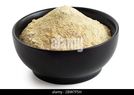 Getrocknetes Linsenmehl in einer schwarzen Keramikschale auf weiß isoliert. Hoher Winkel. Stockfoto