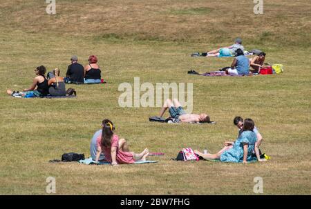 Menschen, die das gute Wetter im Greenwich Park im Süden Londons genießen, werden daran erinnert, nach der Lockdown-Restriktionen soziale Distanzierungen zu praktizieren. Stockfoto