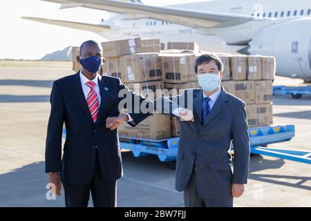 Gaborone, Botswana. Mai 2020. Botswanas Gesundheitsminister Lemogang Kwape (L) und der chinesische Botschafter in Botswana Zhao Yanbo posieren für Fotos während einer Veranstaltung zur Begrüßung von Lieferungen, die China Botswana am 29. Mai 2020 auf dem Sir Seretse Khama International Airport in Gaborone, Botswana, gespendet hat. China hat am Freitag medizinische Schutzgüter nach Botswana gespendet, um dem Land beim Kampf gegen COVID-19 zu helfen. Kredit: Tshekiso Tebalo/Xinhua/Alamy Live News Stockfoto