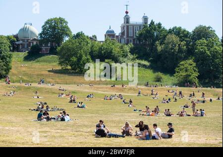 Menschen, die das gute Wetter im Greenwich Park im Süden Londons genießen, werden daran erinnert, nach der Lockdown-Restriktionen soziale Distanzierungen zu praktizieren. Stockfoto