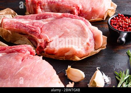 Bio Porco Iberico Französisch Regale über alten rustikalen dunklen Holztisch mit Kräutern und Ingrefienten Seitenansicht aus nächster Nähe gesetzt. Stockfoto