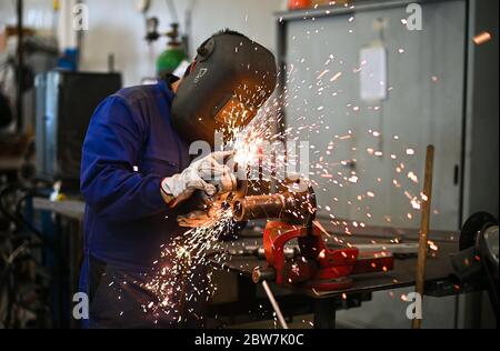 Arbeiter, der einen Winkelschleifer betreibt und viele Funken erzeugt Stockfoto