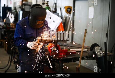 Arbeiter, der einen Winkelschleifer betreibt und viele Funken erzeugt Stockfoto