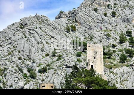 Figurenklettern über der alten Festung Starigrad-Fortica auf dem Gipfel des felsigen Dinara-Berges über der Adria, Omis, Kroatien Stockfoto