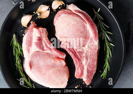 Schweinefleisch Ribeye Braten in Bratpfanne Grill Pfanne mit Kräutern, Gewürze schließen grauen Hintergrund . Nahaufnahme Stockfoto